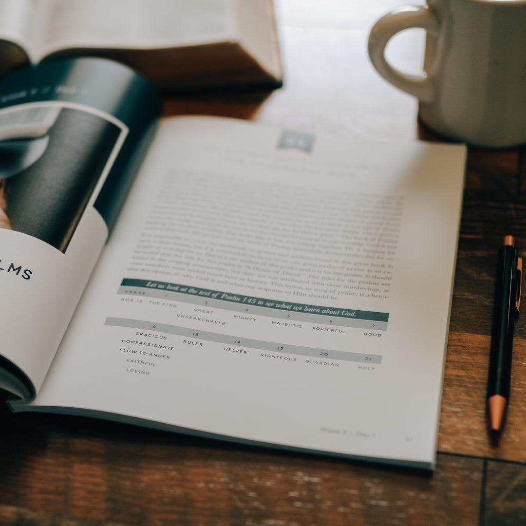 Men's Bible Study on worship sitting on wooden table next to pen