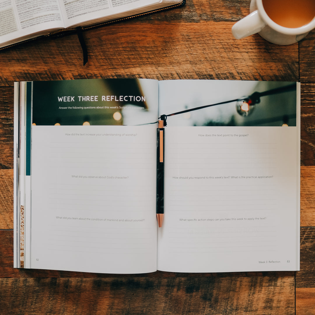 Men's Bible Study on worship sitting open with a pen in the middle of the book