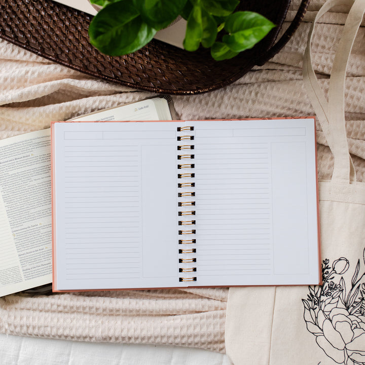 Image of an open journal on top of a Bible and a tote.