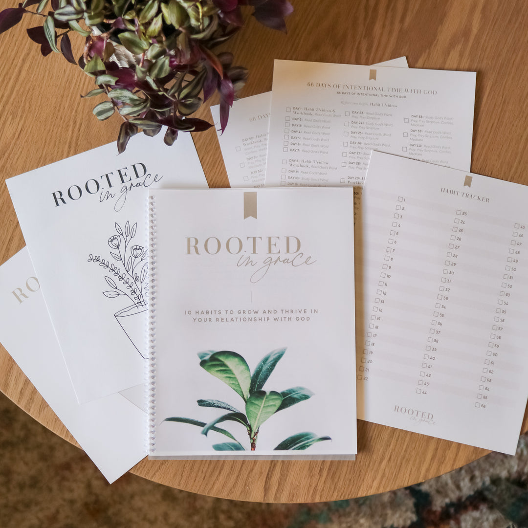 Rooted in Grace workbook and printouts on a wooden table.