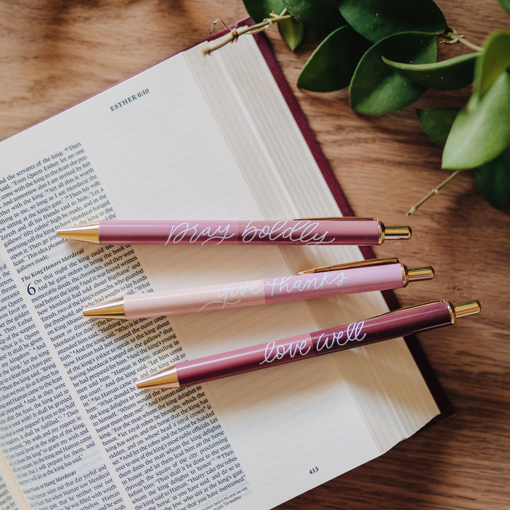 Set of three pink pens on a Bible.