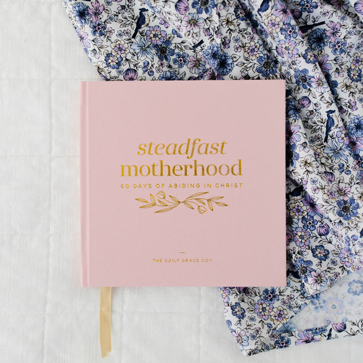 Steadfast Motherhood Devotional showing pink, front cover with gold foil title text.