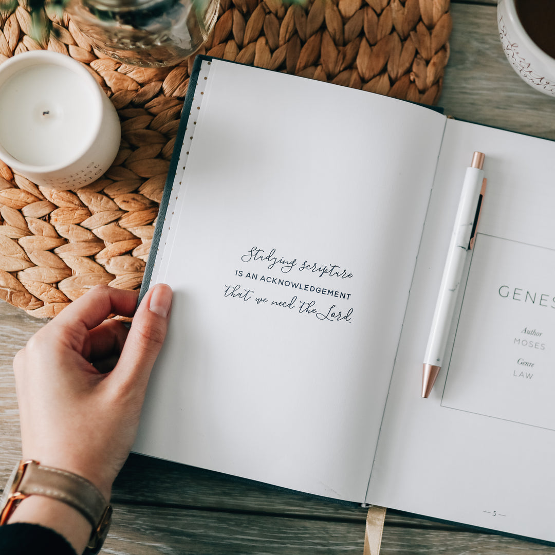 journal open to page with quote next to candle