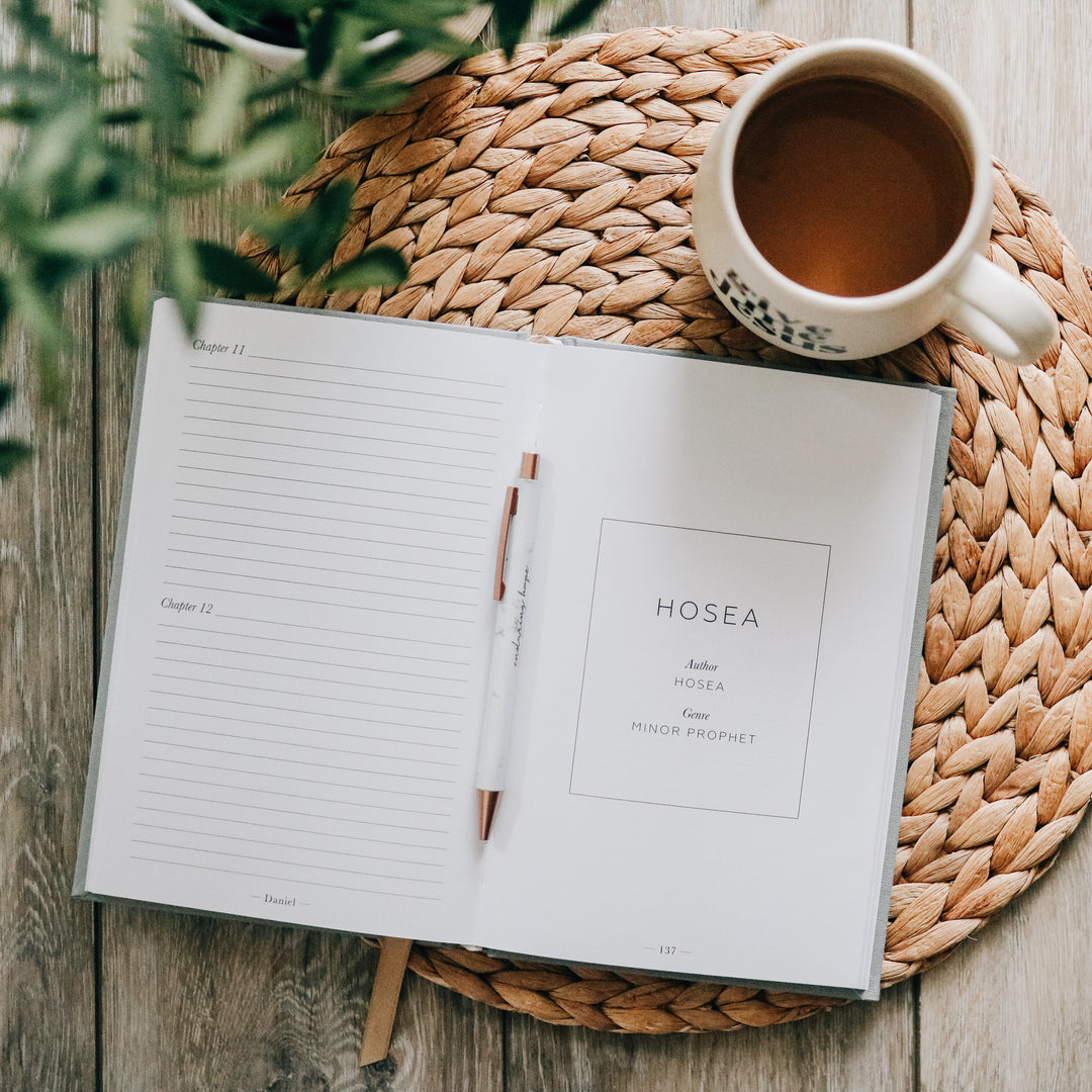 Journal opened to lined pages next to coffee mug