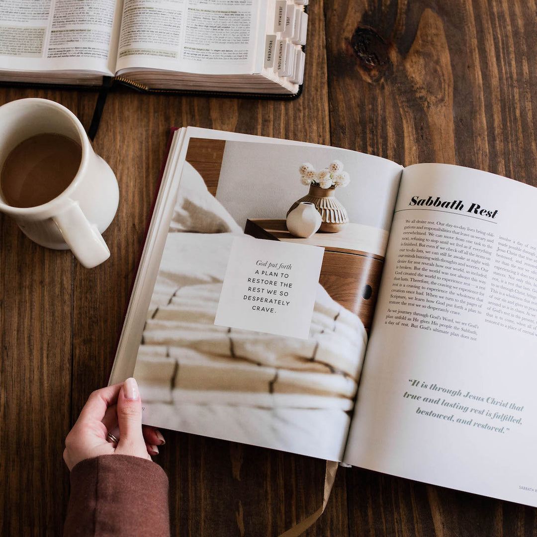 Woman reading through handbook at table next to coffee cup