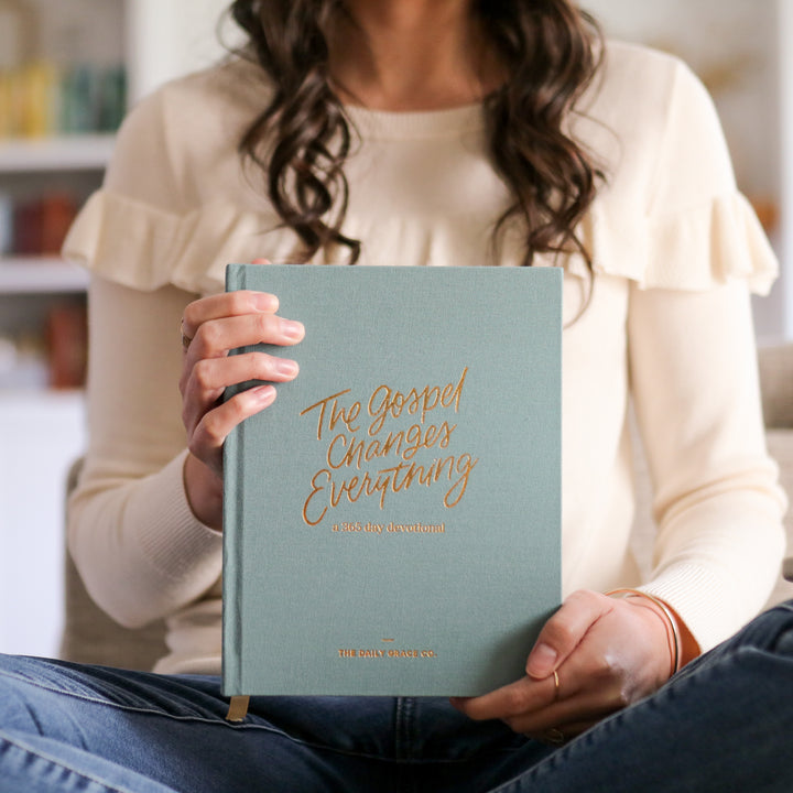 woman holding devotional showing cover