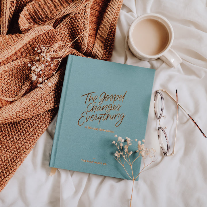 devotional next to glasses and cup of coffee