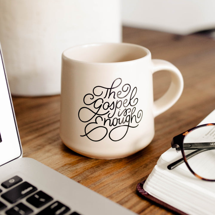 coffee mug next to computer and glasses