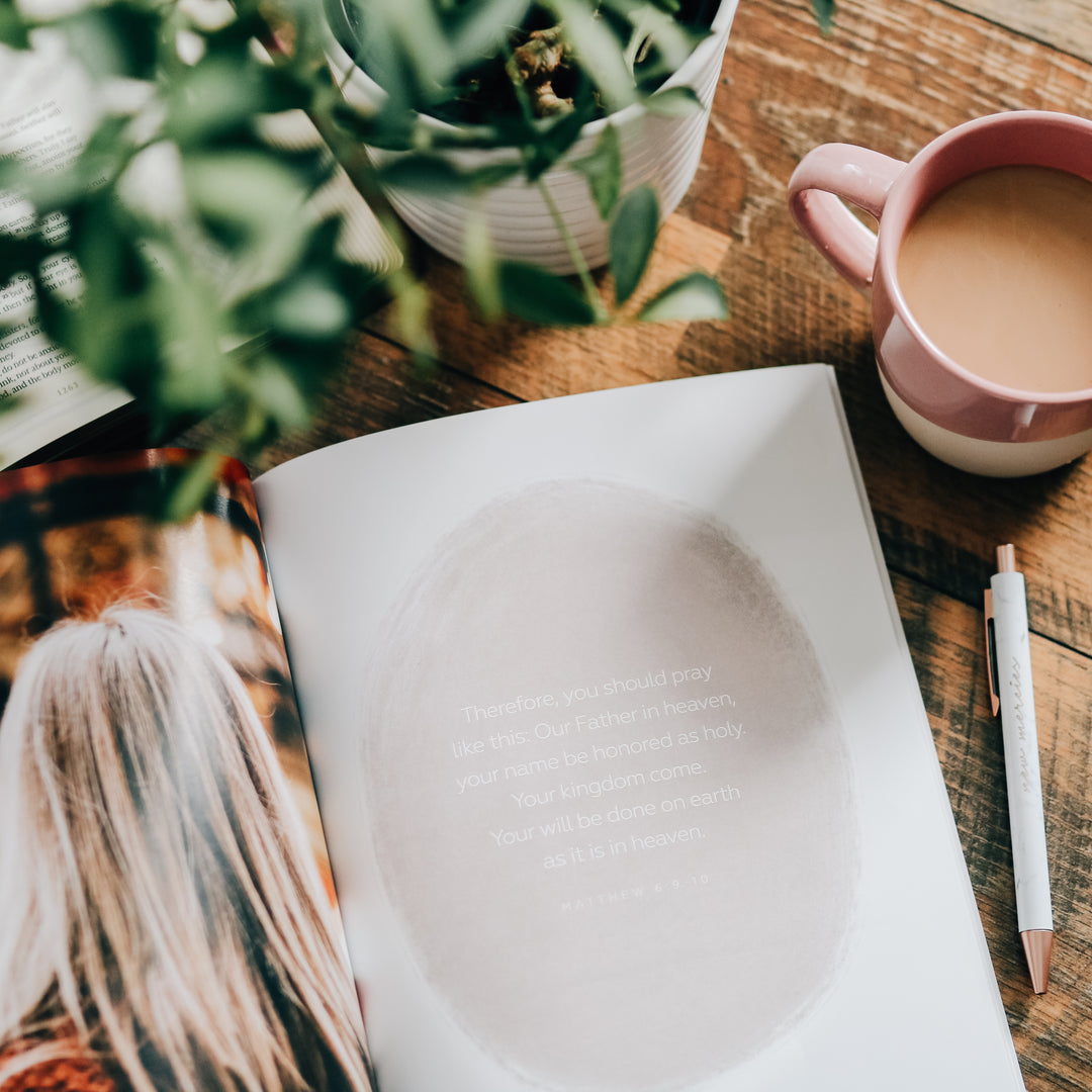 Bible Study open to page with writing next to pen and coffee mug