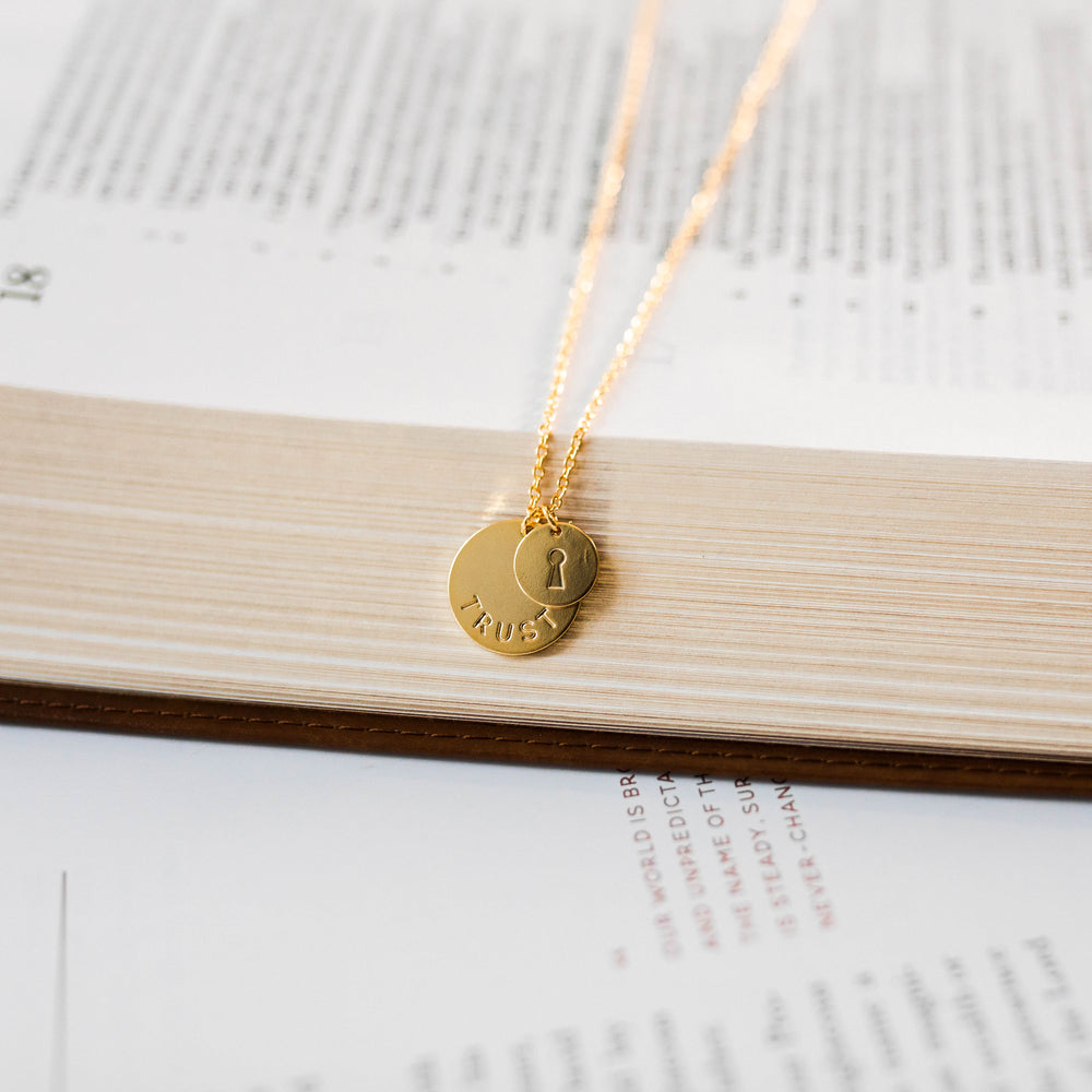 up close photo of necklace that says trust