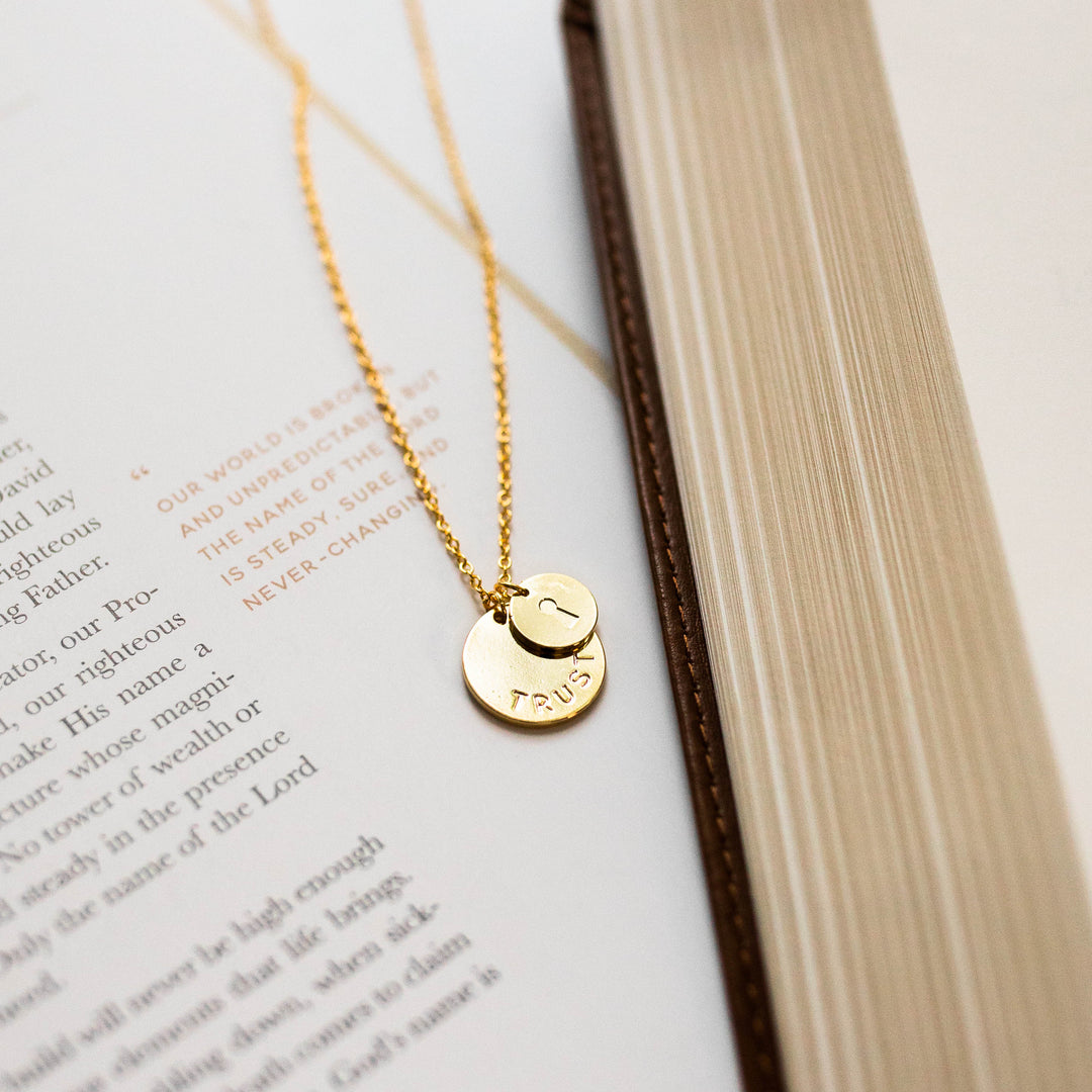 photo of necklace with 2 discs laying on Bible