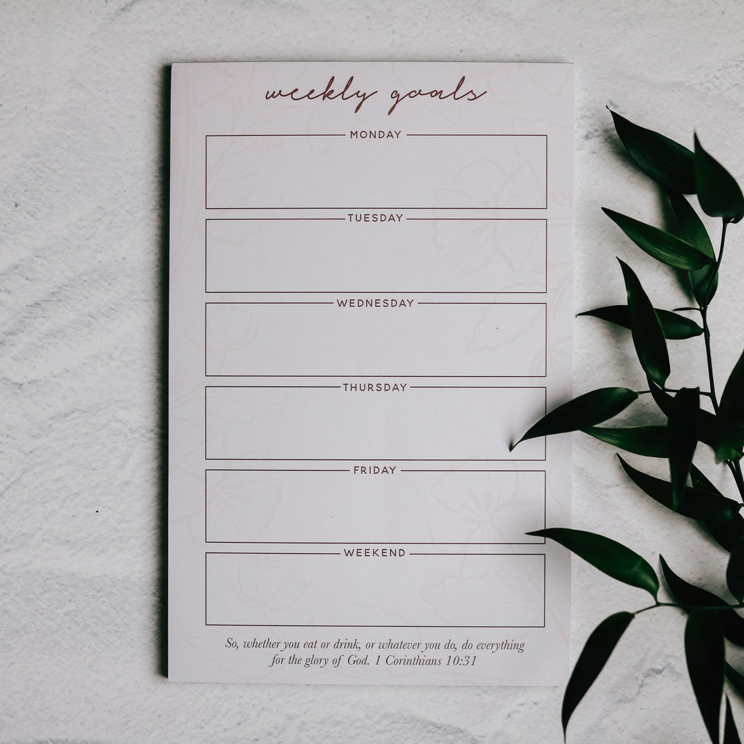 Notepad for writing weekly goals down sitting on table