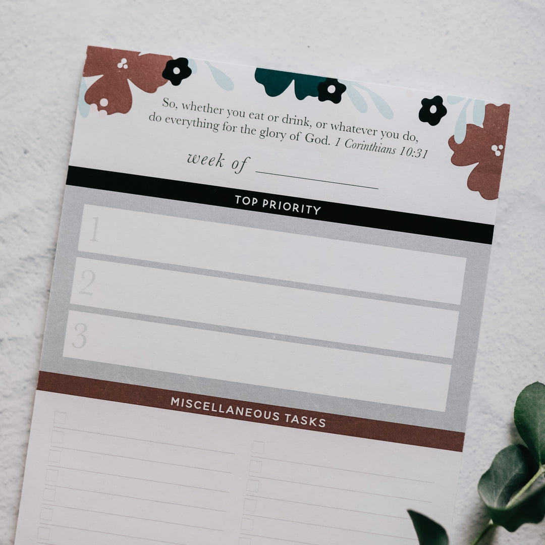 notepad for women to keep track of weekly tasks sitting on clipboard