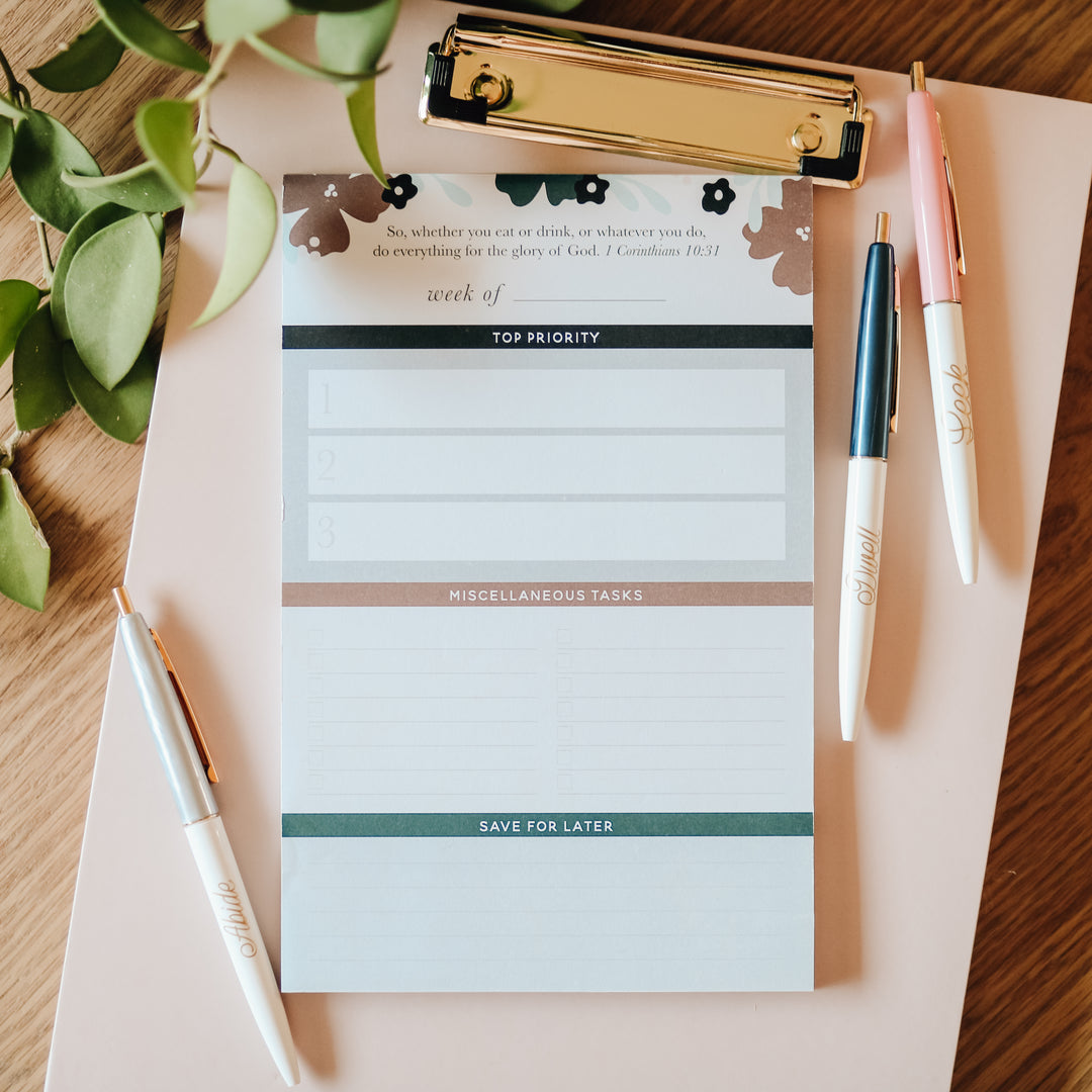 notepad for women to keep track of weekly tasks sitting on clipboard